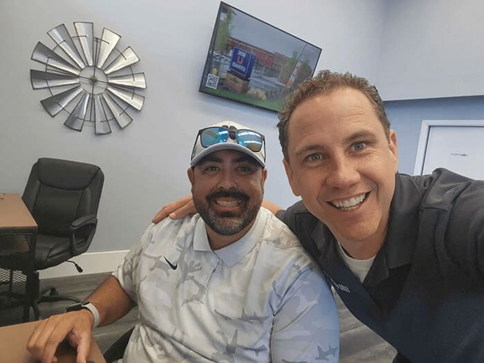 Auto repair shop owner with a happy customer